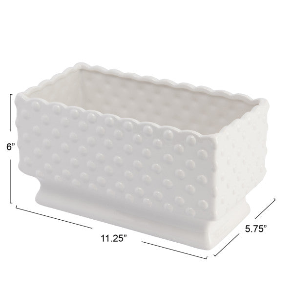 A white ceramic planter with a hobnail texture, scalloped edge, and polka dots.